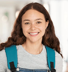student smiling with a backpack on