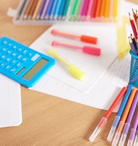 colored markers, blank paper, and calculator on a desk