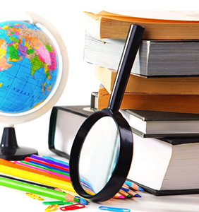magnify glass leaning up against a stack of books, next to a globe