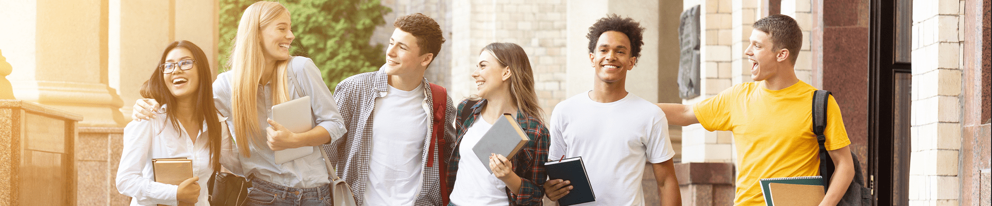 group of high school students laughing as they walk outside
